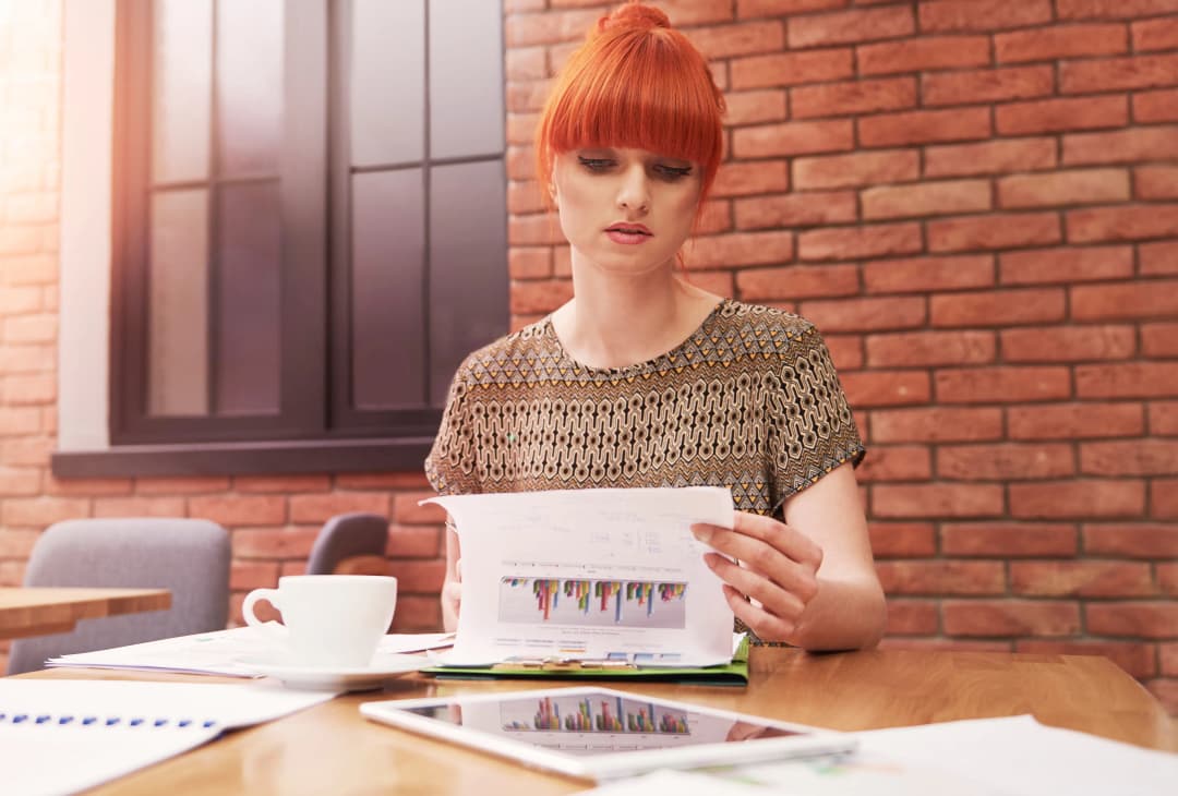 Business professional reviewing corporate filing paperwork with graphs and reports on a desk, business filing paperwork process outdoors